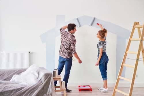 Young,Couple,Painting,The,Interior,Wall,In,Their,New,Apartment